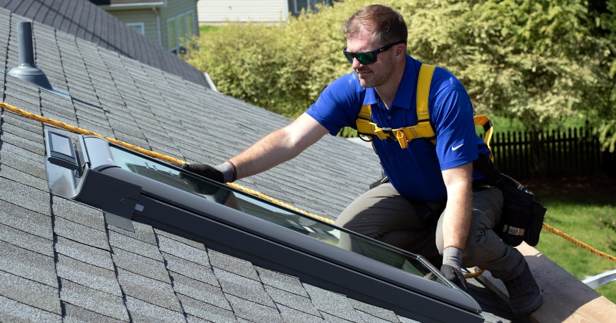 A-skylght-installer-positions-a-skylight-on-a-roof